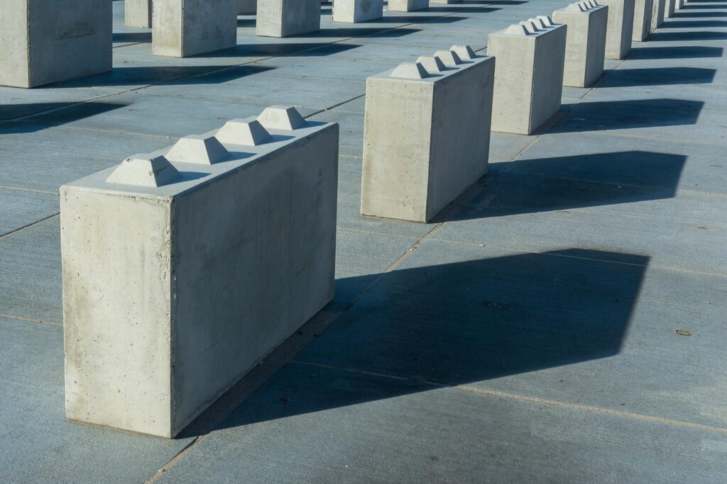 Artistically arranged concrete blocks casting shadows on the ground.